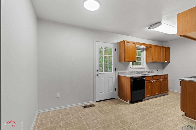209 Norton Dr, Longview, TX 75602 - kitchen with black dishwasher, brown cabinetry, light countertops, stovetop, and baseboards