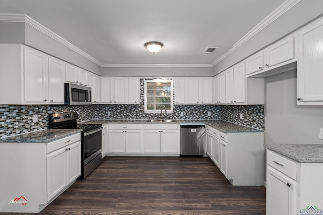 kitchen with sink, white cabinets, dark stone counters, stainless steel appliances, and dark wood-type flooring