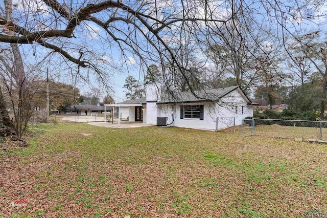 rear view of property featuring a lawn and a patio