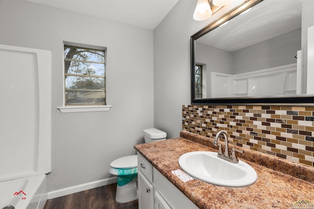 bathroom featuring hardwood / wood-style flooring, vanity, toilet, and decorative backsplash