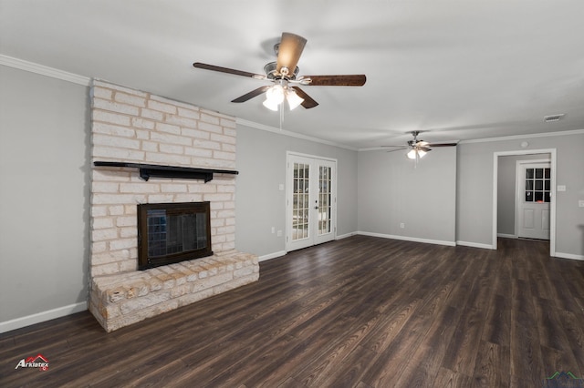 unfurnished living room featuring french doors, dark hardwood / wood-style floors, a brick fireplace, and crown molding