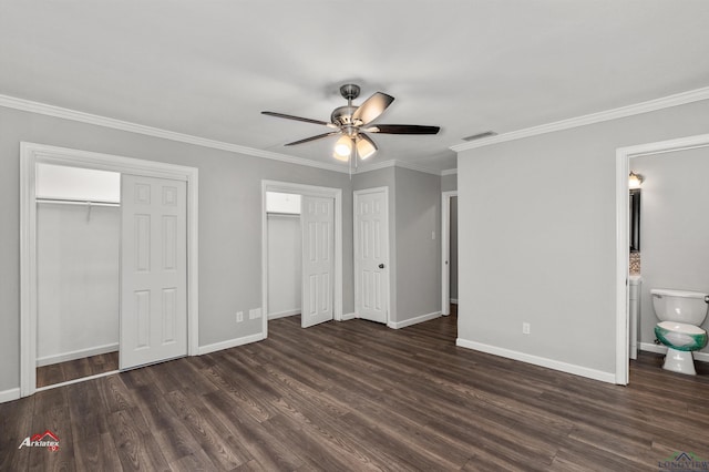 unfurnished bedroom with dark hardwood / wood-style flooring, two closets, and ornamental molding