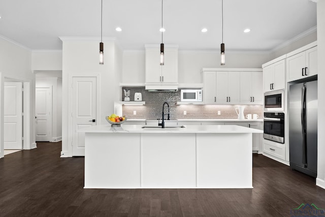 kitchen featuring stainless steel appliances, an island with sink, decorative backsplash, sink, and hanging light fixtures