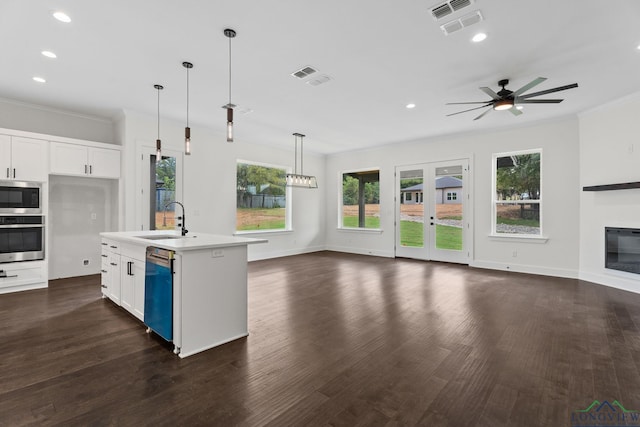 kitchen featuring sink, white cabinetry, hanging light fixtures, an island with sink, and stainless steel appliances