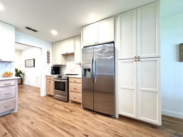 2012 W Lake Dr, Gladewater, TX 75647 - kitchen featuring appliances with stainless steel finishes, tasteful backsplash, light wood-style flooring, and recessed lighting