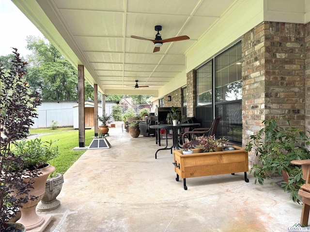 2012 W Lake Dr, Gladewater, TX 75647 - fenced backyard with a ceiling fan, a storage unit, outdoor dining area, and a patio area
