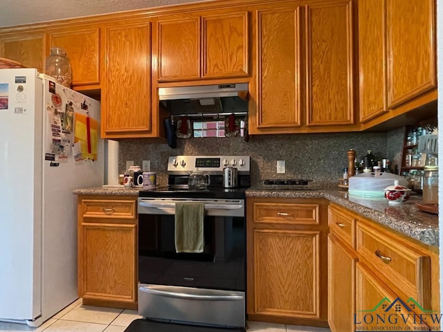 kitchen featuring stainless steel electric stove, tasteful backsplash, light tile patterned floors, and white refrigerator