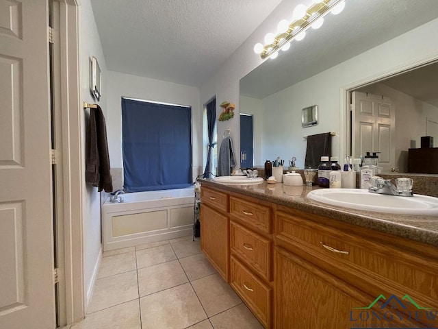 bathroom featuring tile patterned floors, a bathtub, vanity, and a textured ceiling