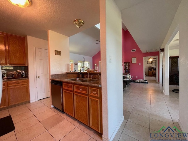 kitchen featuring ceiling fan, dishwasher, lofted ceiling, and sink