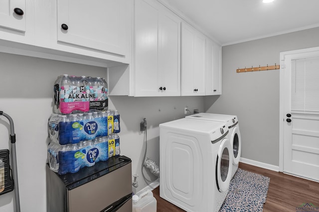 laundry area featuring washer and clothes dryer, cabinet space, dark wood finished floors, baseboards, and ornamental molding