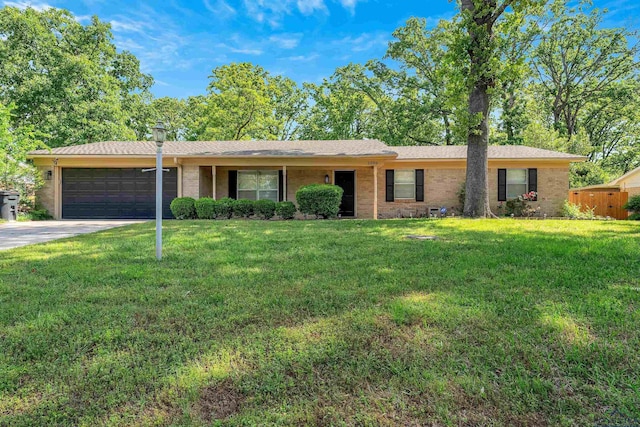 ranch-style home featuring brick siding, an attached garage, a front lawn, and driveway