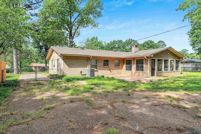 rear view of property featuring a chimney, fence, central AC, a patio area, and brick siding