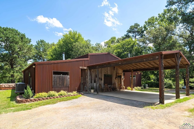 exterior space with gravel driveway, central air condition unit, and a carport