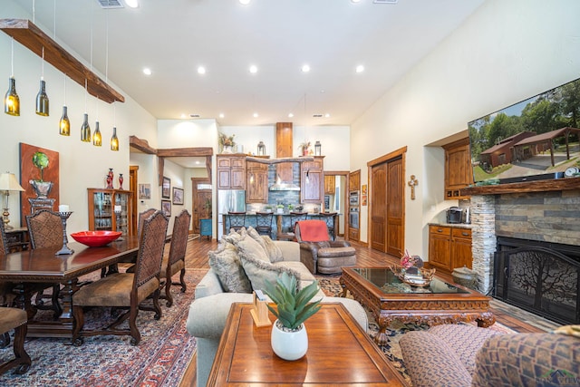 living room with light wood finished floors, a fireplace, a high ceiling, and recessed lighting