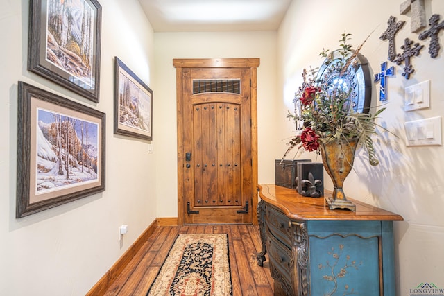 entrance foyer with baseboards and wood finished floors