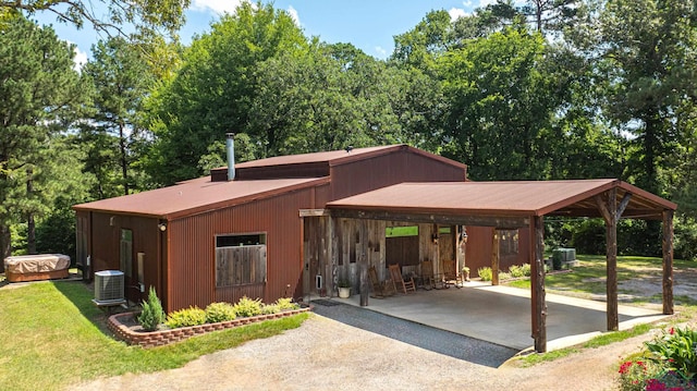 view of front of home featuring central AC unit, a front lawn, aphalt driveway, and a carport