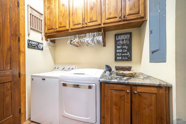 laundry room with cabinet space, electric panel, and separate washer and dryer