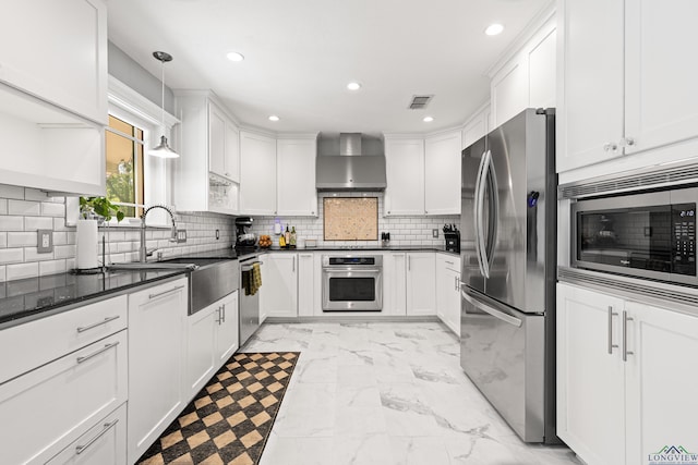 kitchen featuring a sink, stainless steel appliances, wall chimney range hood, marble finish floor, and white cabinets