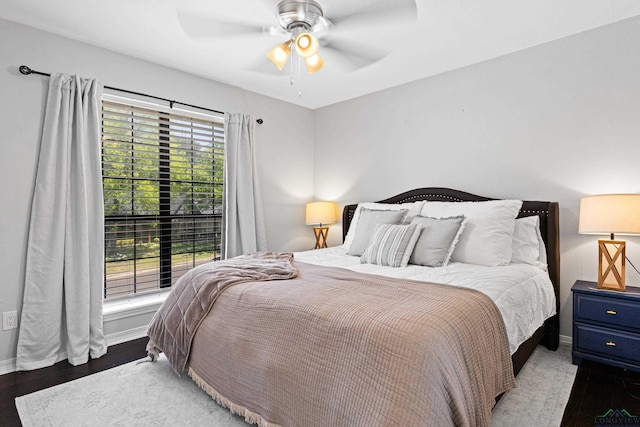 bedroom featuring wood finished floors, baseboards, and a ceiling fan