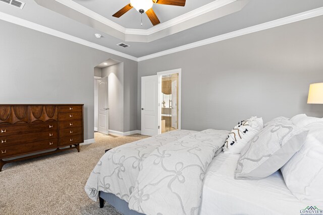 bedroom featuring a tray ceiling, visible vents, baseboards, ornamental molding, and carpet floors