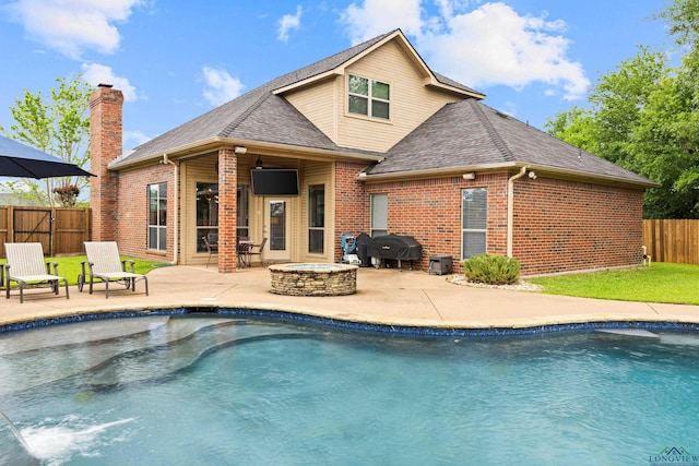 rear view of property with a fenced backyard, brick siding, a shingled roof, a fenced in pool, and a patio