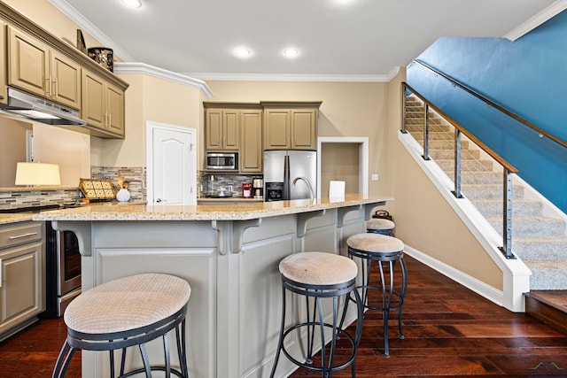 kitchen with stainless steel appliances, dark wood-style floors, baseboards, under cabinet range hood, and ornamental molding