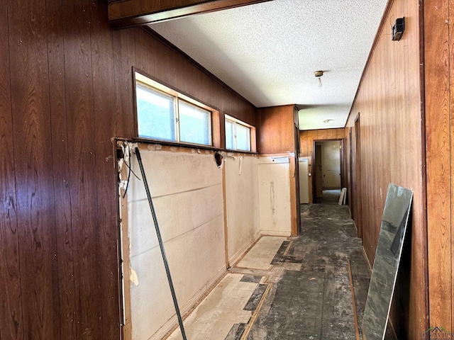 hallway with a textured ceiling and wooden walls