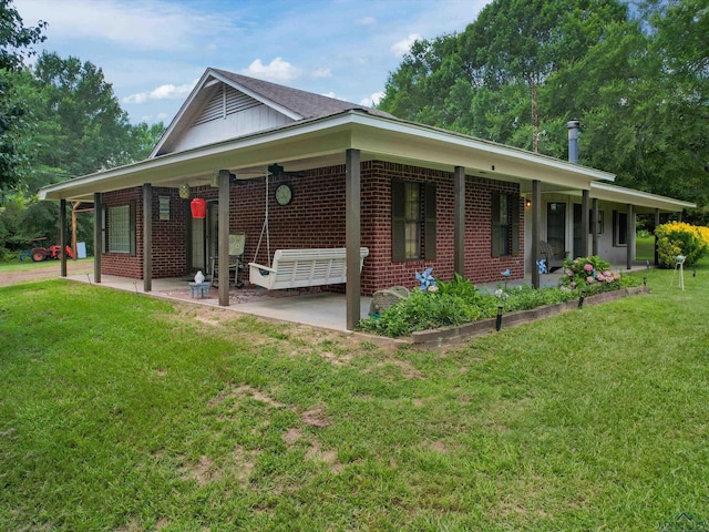 591 N Live Oak Rd, Gilmer, TX 75644 - view of front of home with a front lawn, brick siding, and a patio