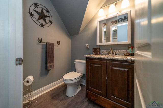 bathroom featuring toilet, hardwood / wood-style floors, vanity, and vaulted ceiling