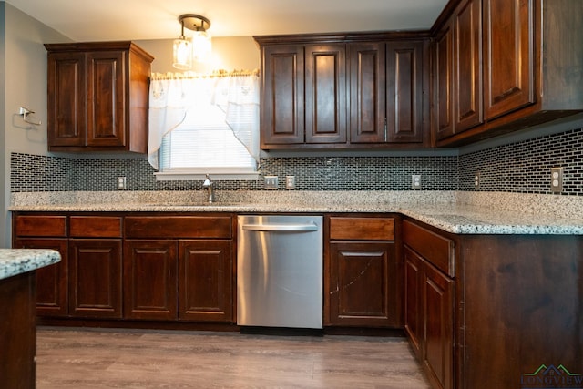 kitchen with light stone countertops, dishwasher, hardwood / wood-style floors, and sink