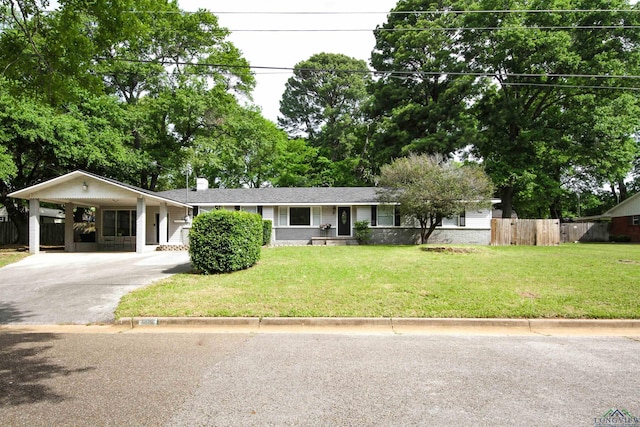 ranch-style home featuring a chimney, driveway, an attached carport, a front yard, and fence