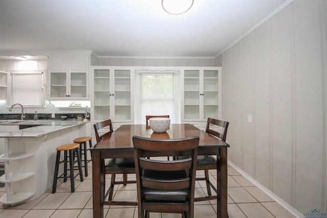 dining room with crown molding and light tile patterned floors
