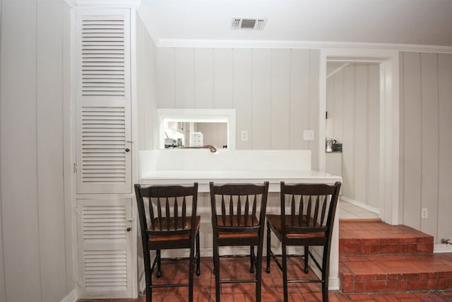 dining space featuring visible vents and brick floor