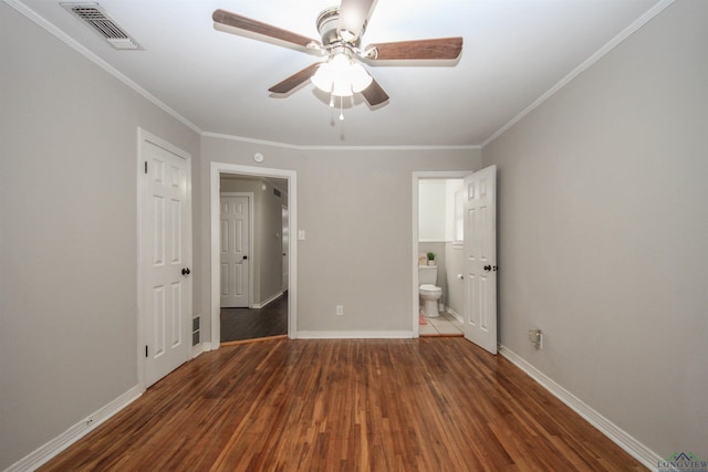 unfurnished bedroom featuring wood finished floors, baseboards, ornamental molding, and visible vents