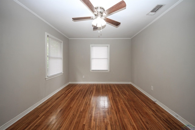 empty room with baseboards, dark wood finished floors, visible vents, and plenty of natural light