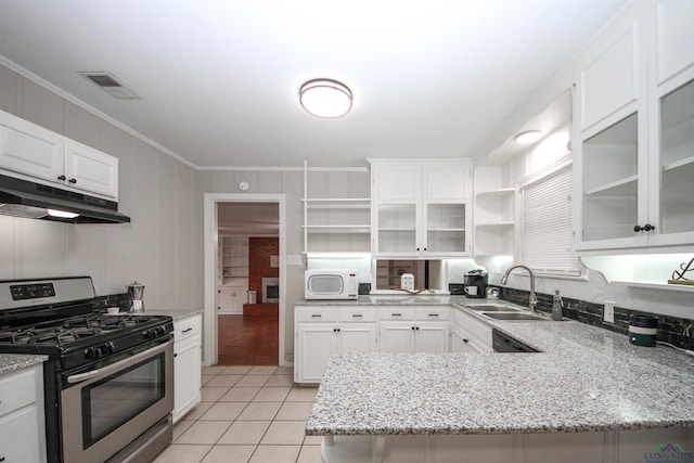 kitchen with open shelves, ornamental molding, under cabinet range hood, white microwave, and stainless steel gas range oven