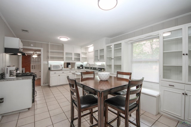 dining space with visible vents, ornamental molding, a ceiling fan, and light tile patterned flooring