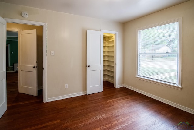 1321 Lake Dr, Longview, TX 75601 - unfurnished bedroom with dark wood finished floors, baseboards, and a spacious closet