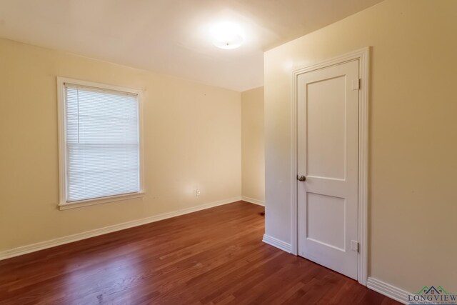 empty room with wood finished floors and baseboards