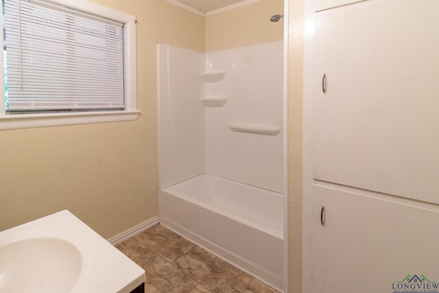 full bathroom with crown molding, baseboards, a sink, and tile patterned flooring