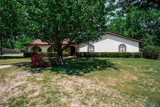 107 Tulip St, White Oak, TX 75693 - view of front facade featuring fence, a front lawn, and brick siding