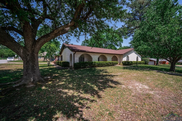 107 Tulip St, White Oak, TX 75693 - view of side of home featuring a yard and brick siding