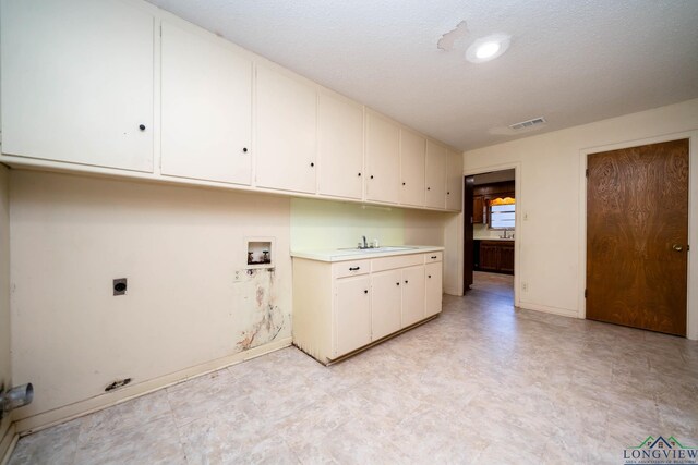 107 Tulip St, White Oak, TX 75693 - laundry area featuring hookup for a washing machine, electric dryer hookup, light floors, baseboards, and cabinet space