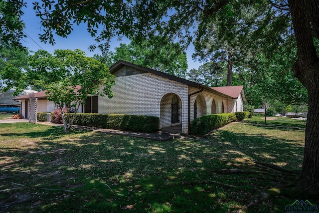 107 Tulip St, White Oak, TX 75693 - tri-level home featuring a garage, a front yard, and brick siding