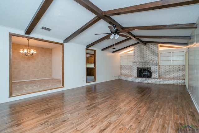 107 Tulip St, White Oak, TX 75693 - unfurnished living room featuring ceiling fan with notable chandelier, lofted ceiling with beams, a fireplace, visible vents, and wood finished floors