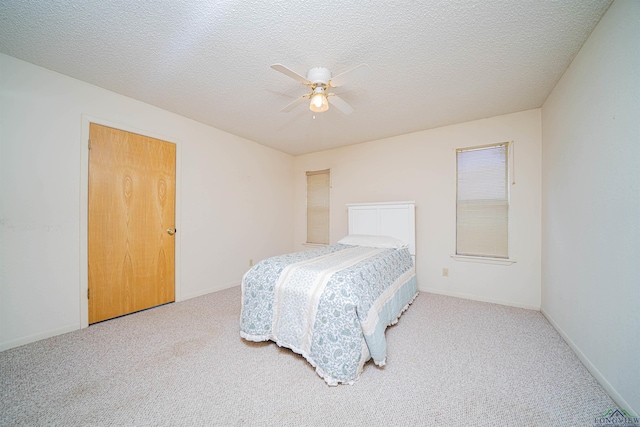 bedroom featuring carpet flooring, ceiling fan, and a textured ceiling