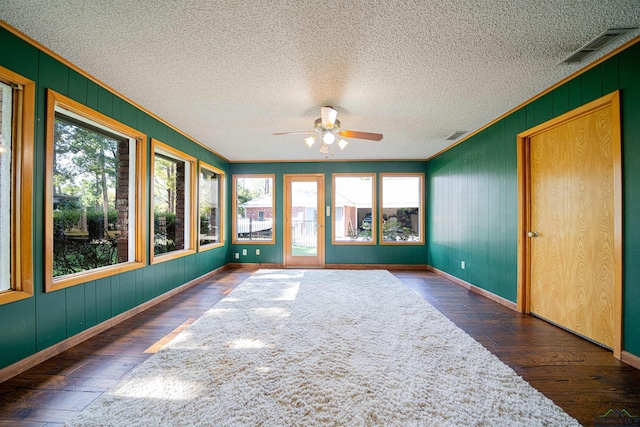 unfurnished sunroom featuring ceiling fan and plenty of natural light