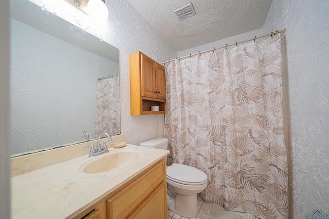 bathroom featuring tile patterned floors, vanity, toilet, and a textured ceiling