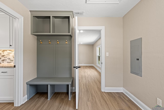 mudroom with light wood-type flooring, electric panel, visible vents, and baseboards