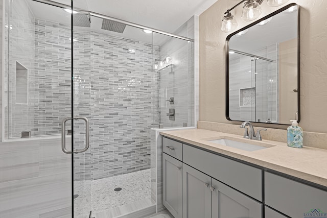 bathroom with a shower stall and vanity